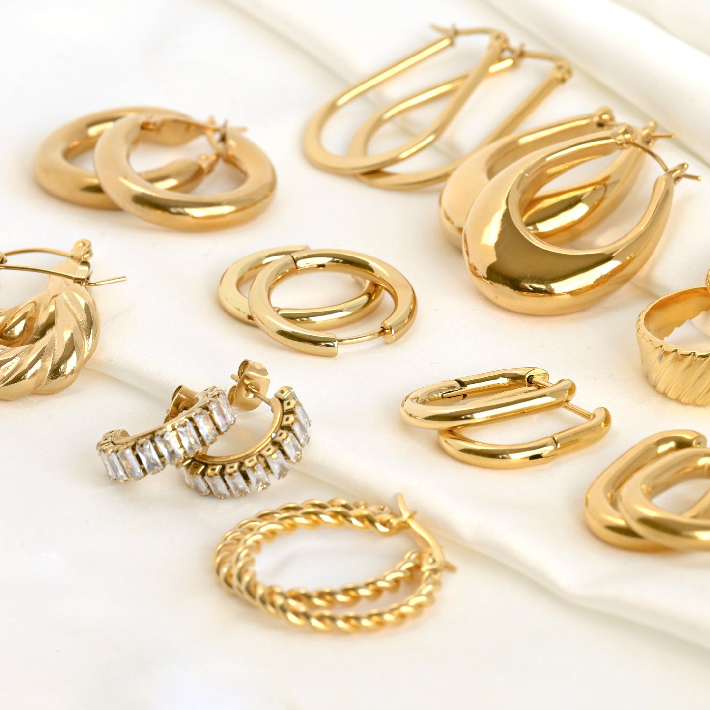 Collection of gold hoop earrings on a white background