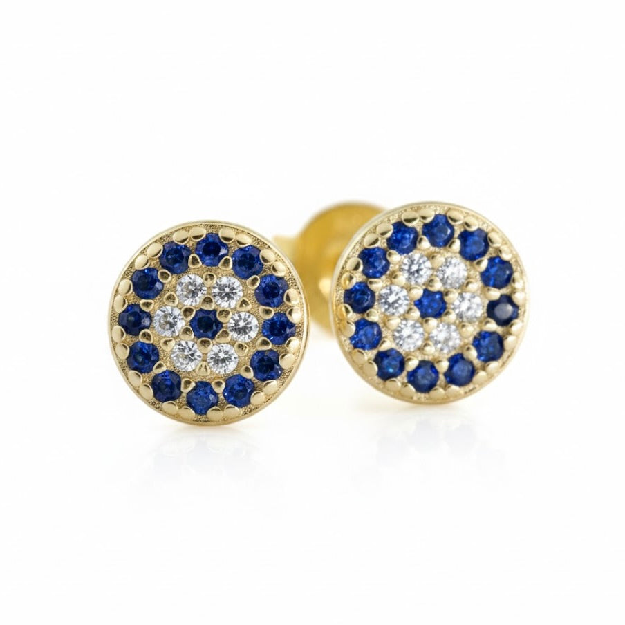 Gold evil eye stud earrings with blue and clear gemstones on a white background