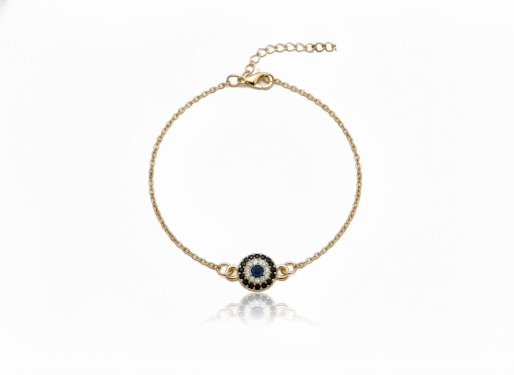 Gold ankle bracelet with a central gemstone on a white background