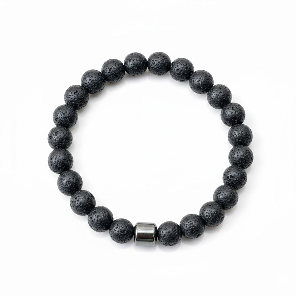 Top view of black lava stone bracelet with a silver bead on a white background