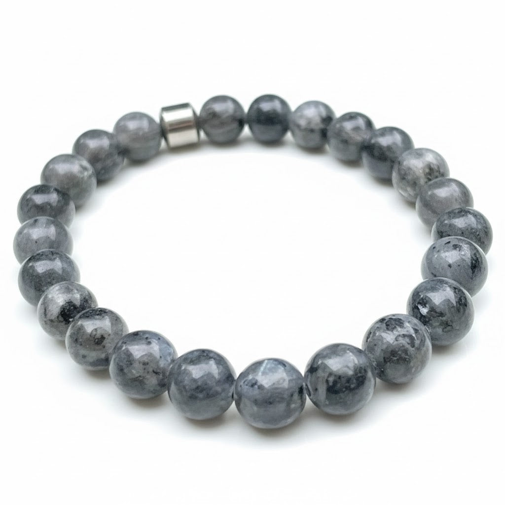 Charcoal map stone bracelet with a metal bead on a white background