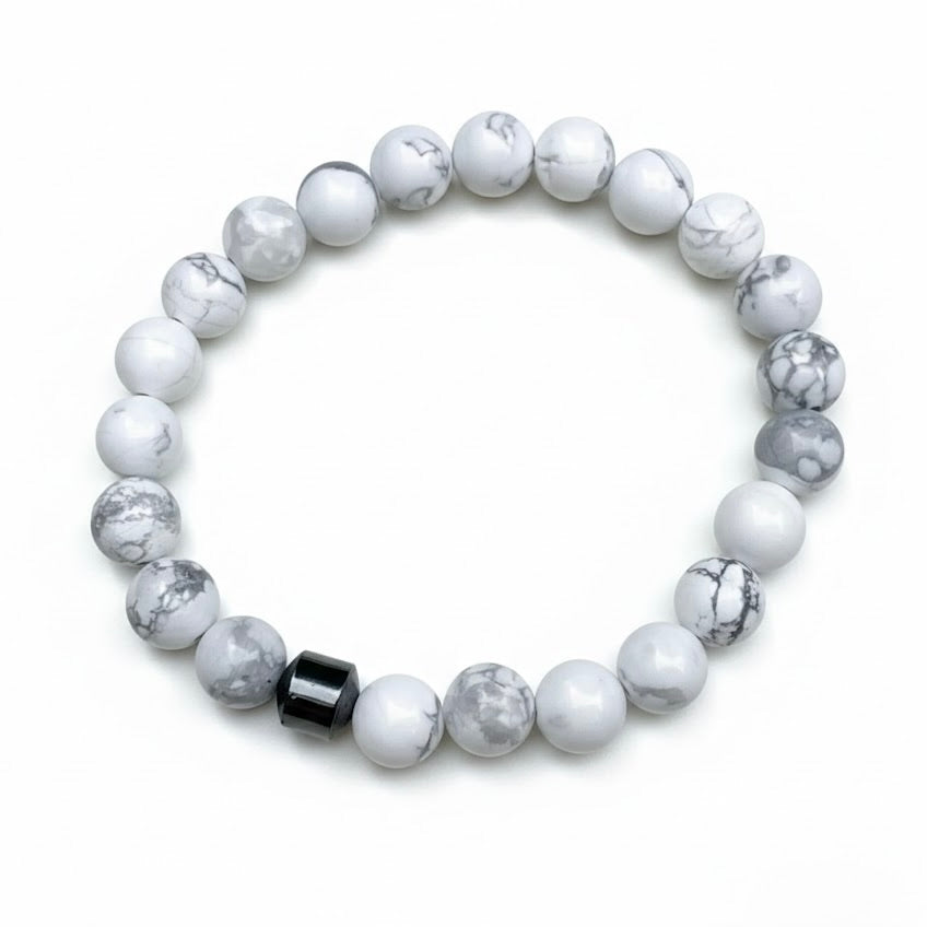 White and gray stone bracelet with a black bead on a white background
