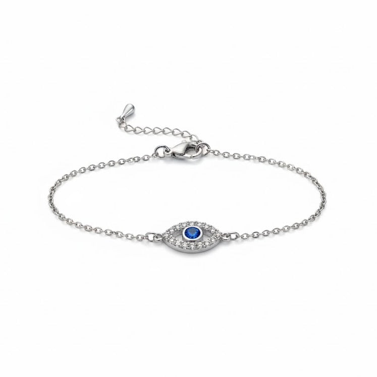 Silver evil eye bracelet with a blue gemstone and tiny crystals around on a white background