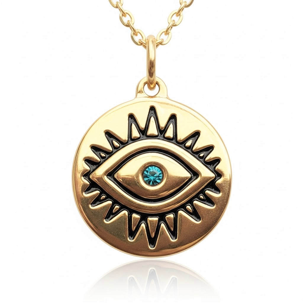 Gold evil eye coin pendant necklace with an ancient eye motif in black and a turquoise crystal centerpiece on a white background