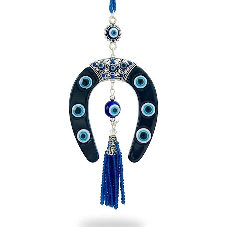 Decorative hanging charm with blue evil eye beads and tassel with a horseshoe design on a white background