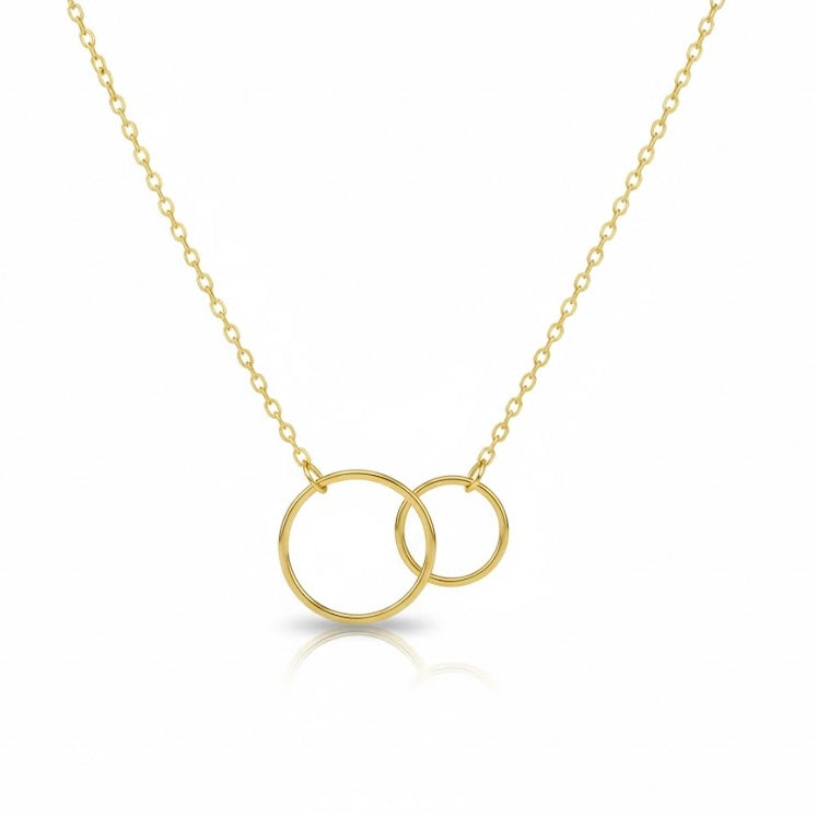 Gold necklace with two interlocking rings on a white background