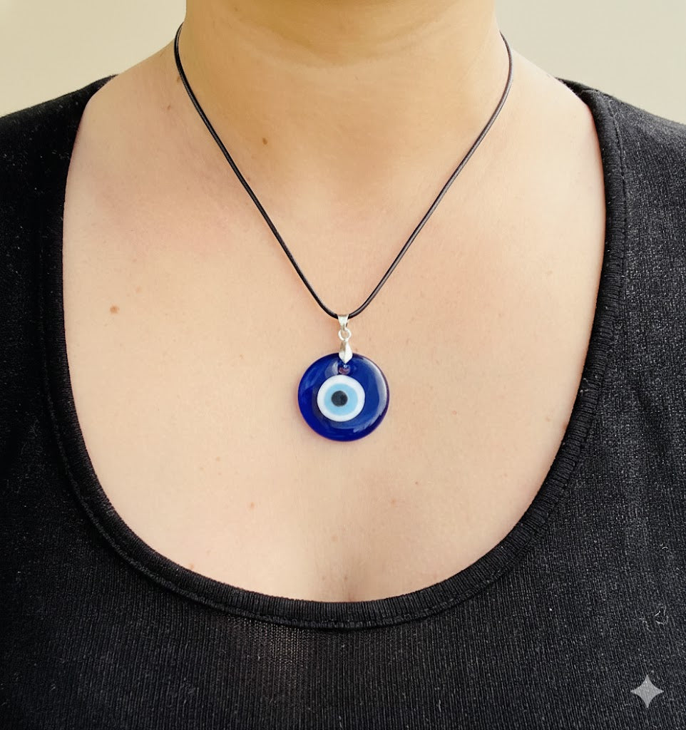 Person wearing a 30mm evil eye pendant necklace made of glass on a plain background