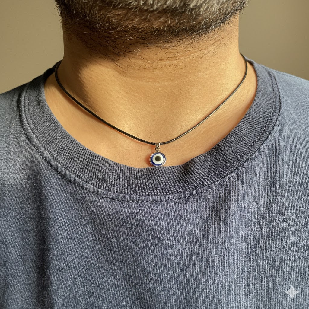 Necklace with an eye pendant worn by a man against a neutral background