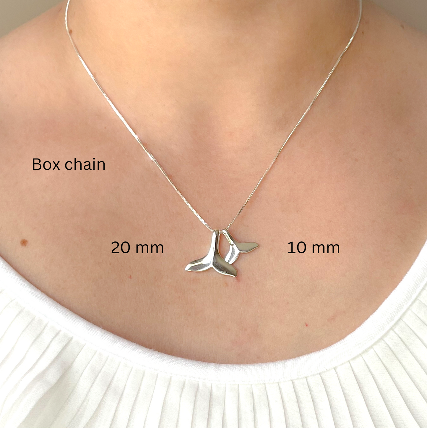 Silver necklace with whale tail pendant on a person's neck, labeled for chain type and dimensions.